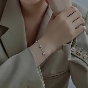 Détail du bracelet en argent S925 avec trois breloques papillon porté par un mannequin