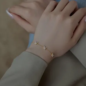 Détail d'un bracelet papillon doré avec pierres marquises porté par un mannequin féminin