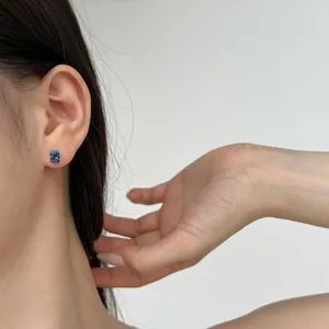 Rectangle cut blue gemstone earrings in 925 silver setting worn by a female model