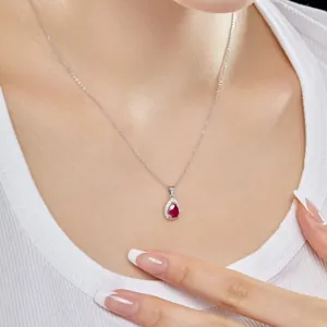 Gros plan d'un collier en argent S925 avec pendentif poire en zircon rouge sur un mannequin
