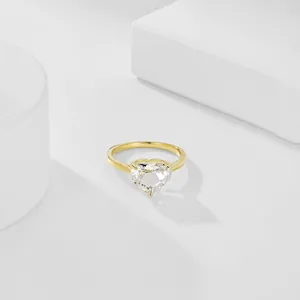 Macro shot of a heart-cut clear gemstone ring with elegant 18K gold plated prong setting