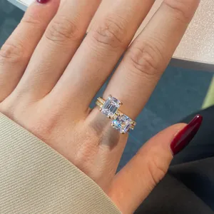 Close-up of Toi et Moi gold ring featuring two emerald-cut stones and pavé set band