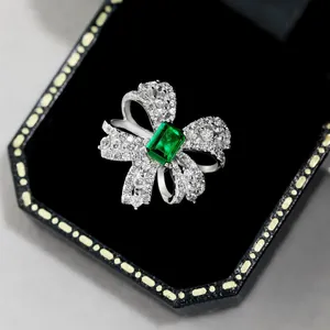Makroaufnahme der Schleifenschleife mit smaragdgrünem Stein und Diamanten in Box