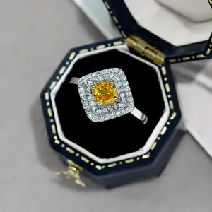 Makroaufnahme eines gelben Edelsteinrings mit Double-Halo in blauer Samtbox aus S925 Silber