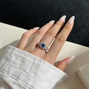 Macro shot of 925 silver ring featuring a rectangle blue stone and diamond halo