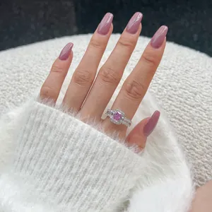 Detail of a rectangle pink stone ring with halo setting on a model's hand