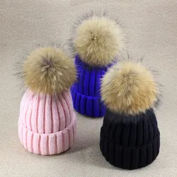 Trois bonnets d'hiver en maille épaisse avec pompons en fausse fourrure rose, bleu et noir