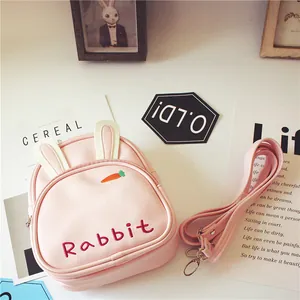 Detailansicht eines rosa Kaninchen-Minirucksacks mit Stickerei und 3D-Ohren auf Tisch