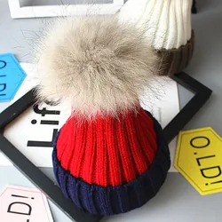 Détail du bonnet tricoté enfant rouge et bleu marine avec pompon en fausse fourrure