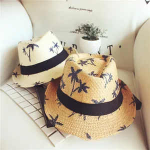 Detail of woven straw hats featuring navy palm tree prints and black ribbon trim
