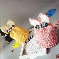 Détail de bérets en laine tricotés rose et jaune avec oreilles de lapin et nœuds