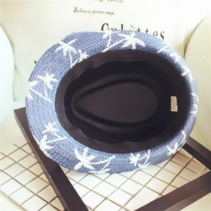 Detail of navy straw fedora hat with white coconut tree pattern and size 54 inner label