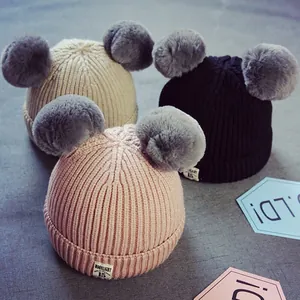 Bonnet tricoté pour bébé avec protège-oreilles et double pompon en rose noir et beige