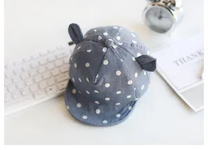 Detailansicht der Baby-Schirmmütze mit blauen Punkten und süßen Tierohren-Design