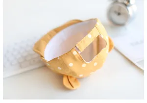 Detailsicht der gelben Babykappe mit Punkten, Innenfutter und verstellbarem Klettverschluss