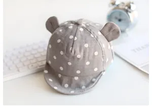 Detailaufnahme einer grauen Baby-Baseballmütze mit weißen Punkten und süßen kleinen Ohren