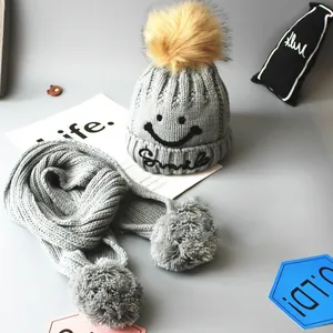 Kids grey knit hat and scarf set with embroidered smiley face and pompom detail