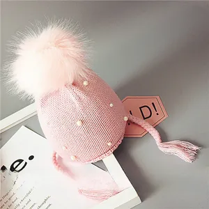 Bonnet en tricot rose pour bébé avec pompon en fourrure et perles blanches