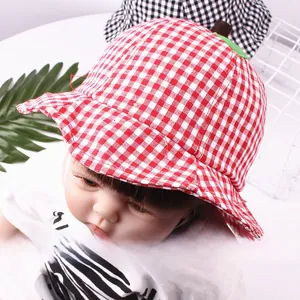 Close-up of red and white plaid baby sun hat with cute green leaf apple design