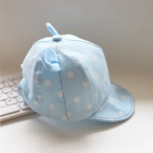 Detail der Baby-Sonnenmütze mit weißen Punkten auf weichem hellblauem Baumwollstoff