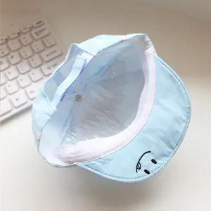 Detail der hellblauen Baby-Punktmütze mit weicher Krempe und Smiley-Stickerei