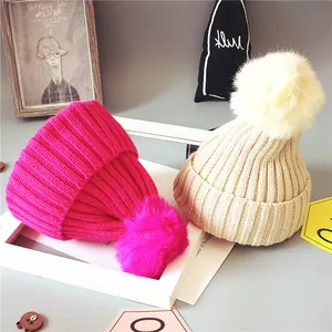 Bonnets en tricot pour bébé en rose et crème avec pompons moelleux pour l'hiver