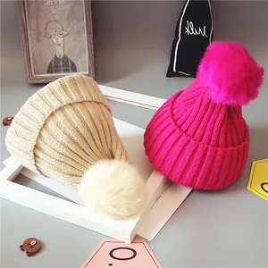 Bonnets d'hiver en maille pour bébés avec grands pompons en fausse fourrure crème et rose vif