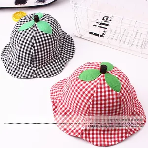 Detail of checkered baby sun hats with leaf accents and breathable cotton fabric texture