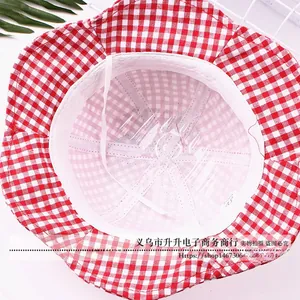 Detail view of red and white plaid baby sun hat with windproof strap and cotton lining