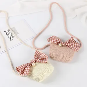 Kids woven straw crossbody bags with large red gingham bows and pearl accents