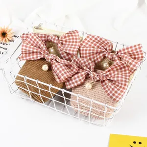 Kids woven crossbody bag with plaid bow and pearl charm in brown and beige tones