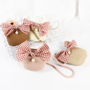 Close-up of four colorful straw crossbody bags for girls with large pink plaid bows