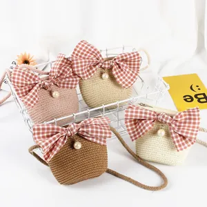 Close-up of girls straw woven crossbody bags in four colors with plaid bow and pearl