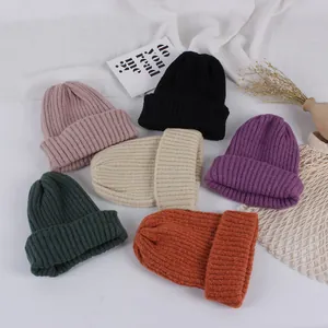 Winter knit hats for children in multiple colors with cozy ribbed texture and dual pom-poms