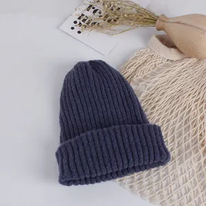 Detail of navy blue ribbed knit hat for kids with thick texture in lifestyle setting