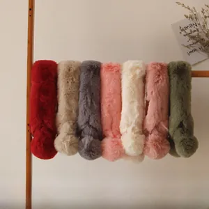Détail de sept couleurs d'écharpes en peluche avec de doux détails de pompons
