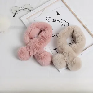 Gros plan d'écharpes en peluche rose et beige en fausse fourrure de lapin avec pompons