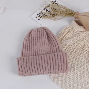 Detail of dusty pink ribbed knit beanie with thick fold-up cuff for winter warmth