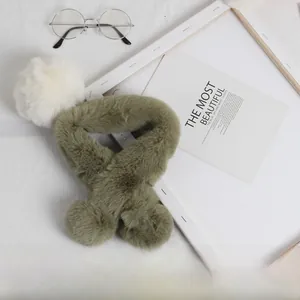 Détail de l'écharpe en fausse fourrure vert herbe pour enfants avec pompons blancs doux