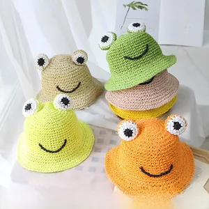 Détails de chapeaux de soleil grenouille en paille tressée avec yeux de dessin animé