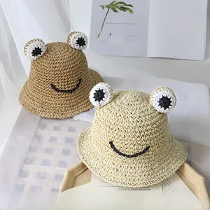 Détails d'un chapeau de paille grenouille fait main avec yeux 3D et texture tressée
