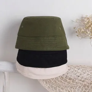 Tre cappelli a secchiello in tela di cotone in oliva, nero e beige su scaffale