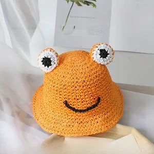 Gros plan du chapeau de soleil orange en paille avec yeux de grenouille mignons