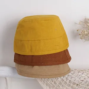 Cappelli a secchiello in cotone per bambini impilati nei colori giallo, marrone e kaki