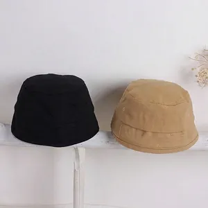 Dettaglio di cappelli pescatore in tela tinta unita per bambini in nero e kaki