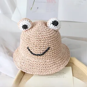 Détail d'un chapeau de paille grenouille avec texture tissée et décorations d'yeux