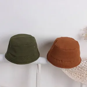 Dettaglio della trama in tela e cuciture di cappelli da pescatore per bimbi verde e caramello