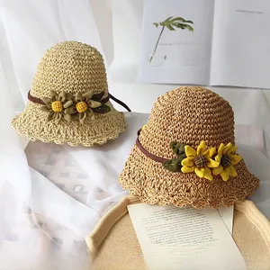 Détail de chapeaux d'été en paille tissés main avec fleurs au crochet et dentelle