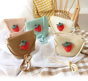 Detail showing five colors of kids straw crossbody bags with 3D strawberry patches