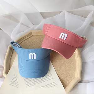 Detail view of cotton sun visors in blue and pink with letter m embroidery for kids